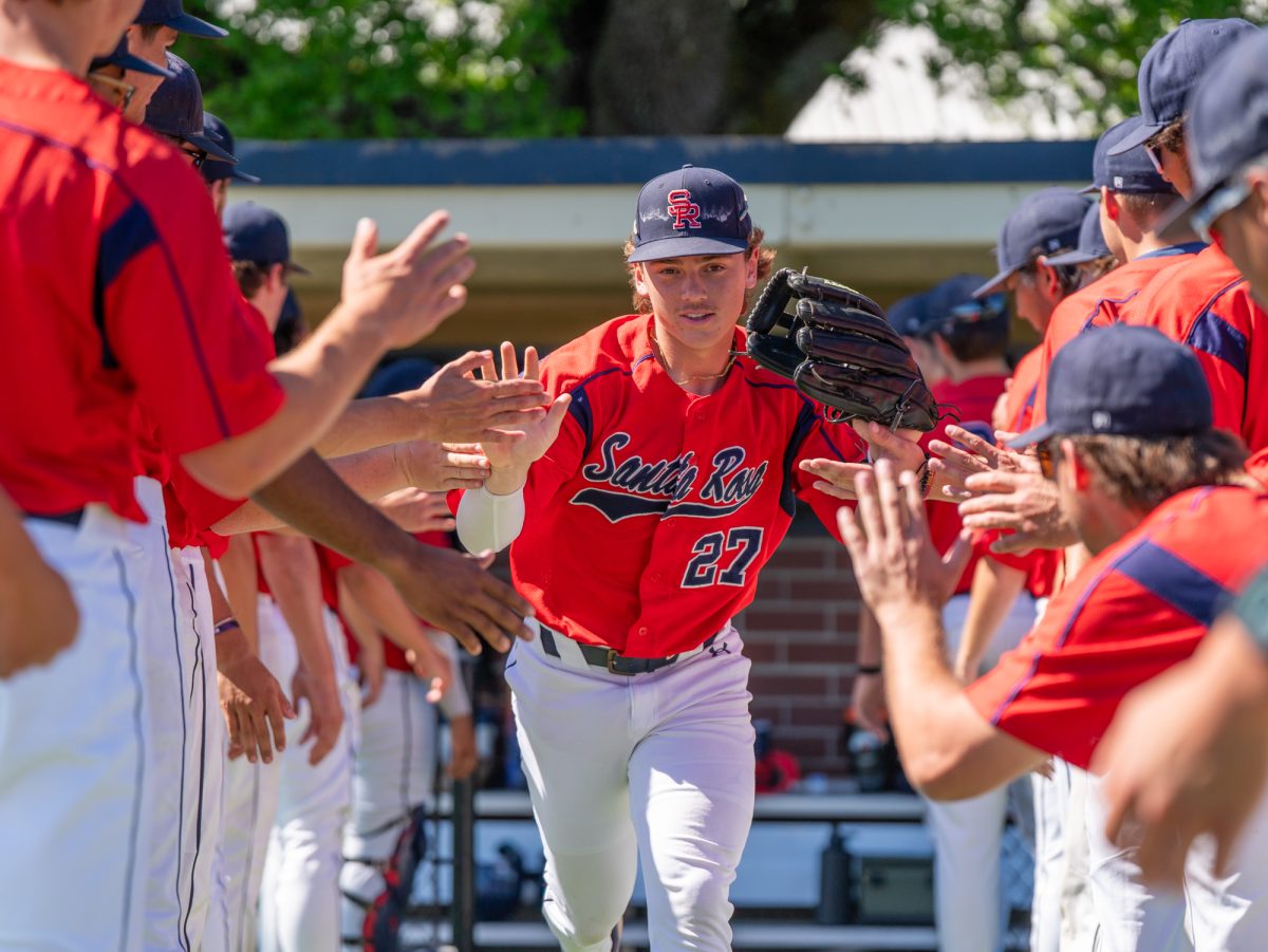 Right fielder Miles Clayton runs through a tunnel of teammates during lineup announcements against American River College at home on Thursday, March 19, 2026.