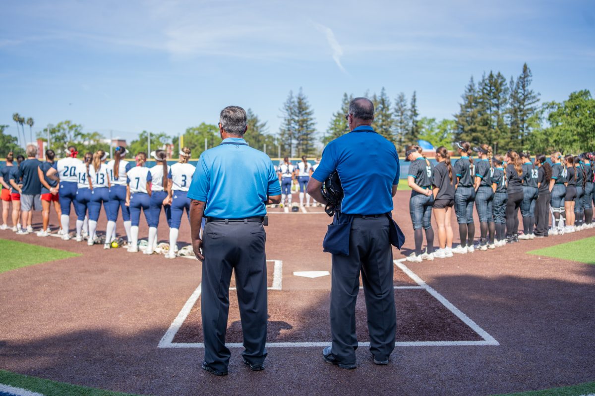 Officials stand behind home plate while Santa Rosa and Folsom Lake College take their places on the field as the national anthem plays overhead prior to the first game of the day at home on Saturday, March 28, 2026.