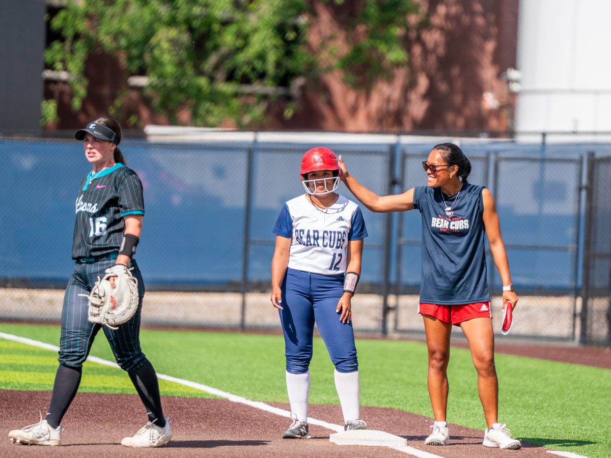 Santa Rosa first base coach Anna Zoia-Buescher taps Brianna Allen's helmet after Allen's single to center gets her on base in the second game against Folsom Lake College at home on Saturday, March 28, 2026.