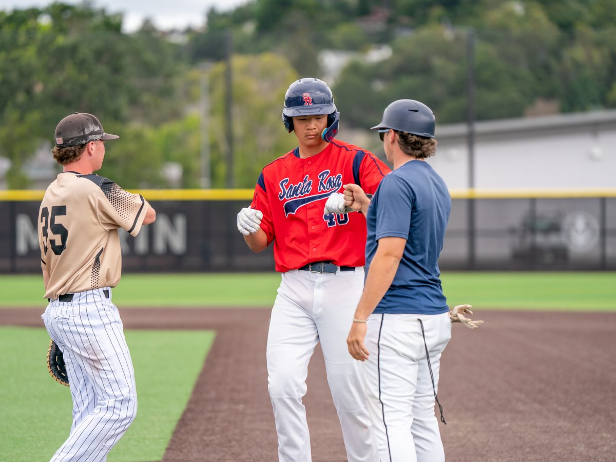 Designated hitter Aidan Sakai fist bumps first base coach Connor Charpiot after hitting a single in the bottom of the second against College of Marin on Sunday, May 3, 2026.