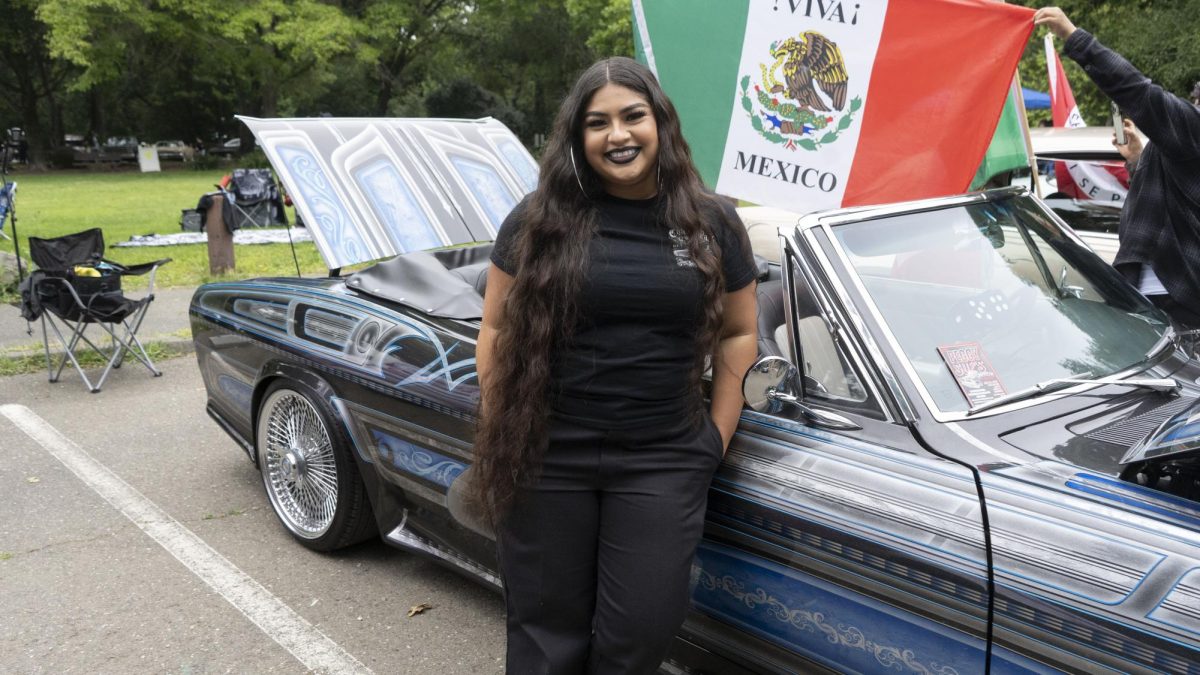 Crystal Favela Bautista "Lowrider Lady" with her converted body swap car “The Blue Print," which is a 2004 Honda Accord underneath and a 1965 Chevy Covair on top. 