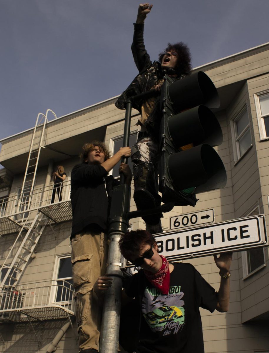 Protesters make their voices heard while they hang onto a traffic light, chanting to abolish Immigration and Customs Enforcement during the ICE Out protest at Dolores Park in San Francisco, Jan. 30, 2026.
